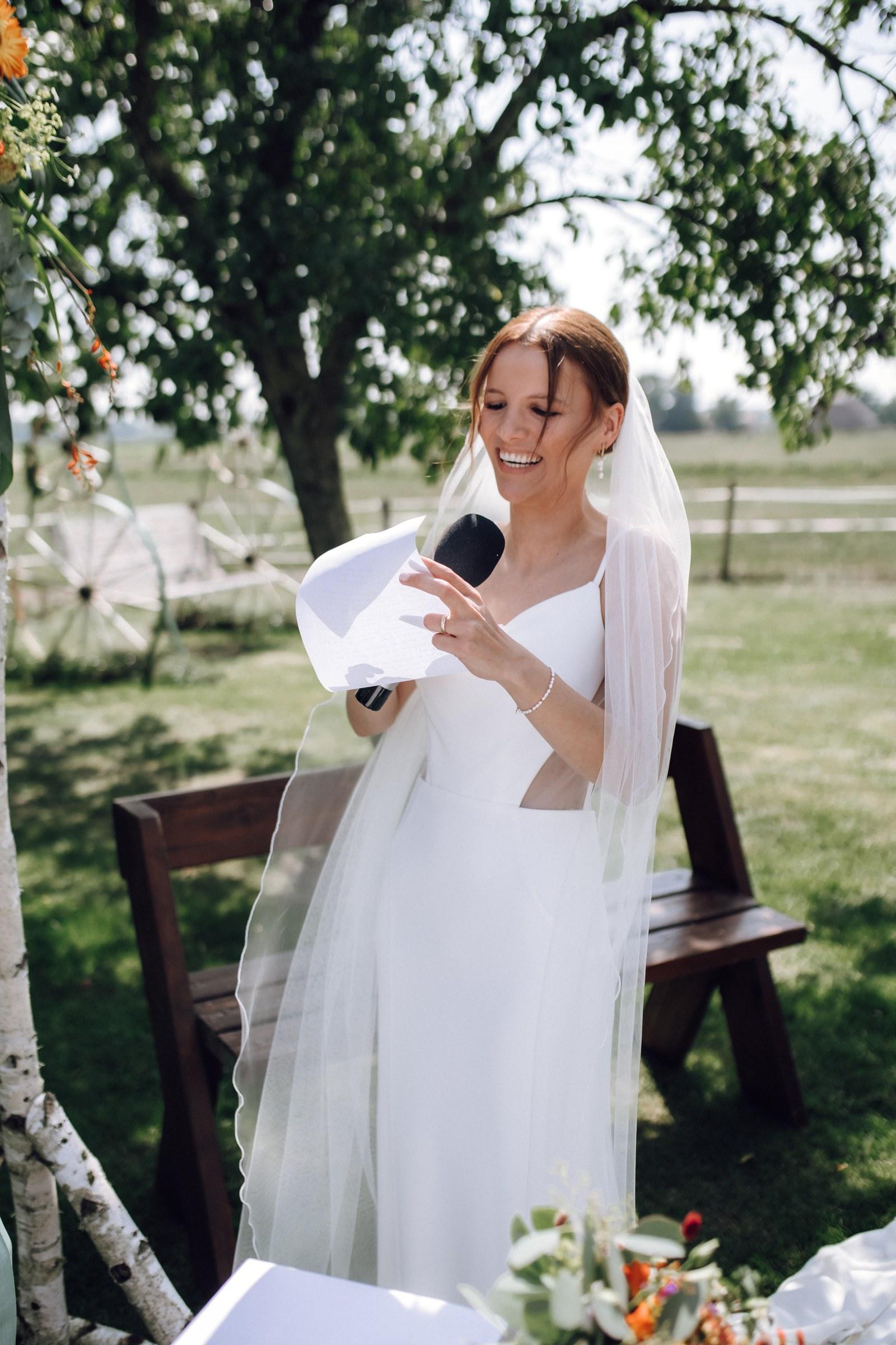 Celine liest lachend ihre Gelübde vor, in der Hand das Mikrofon